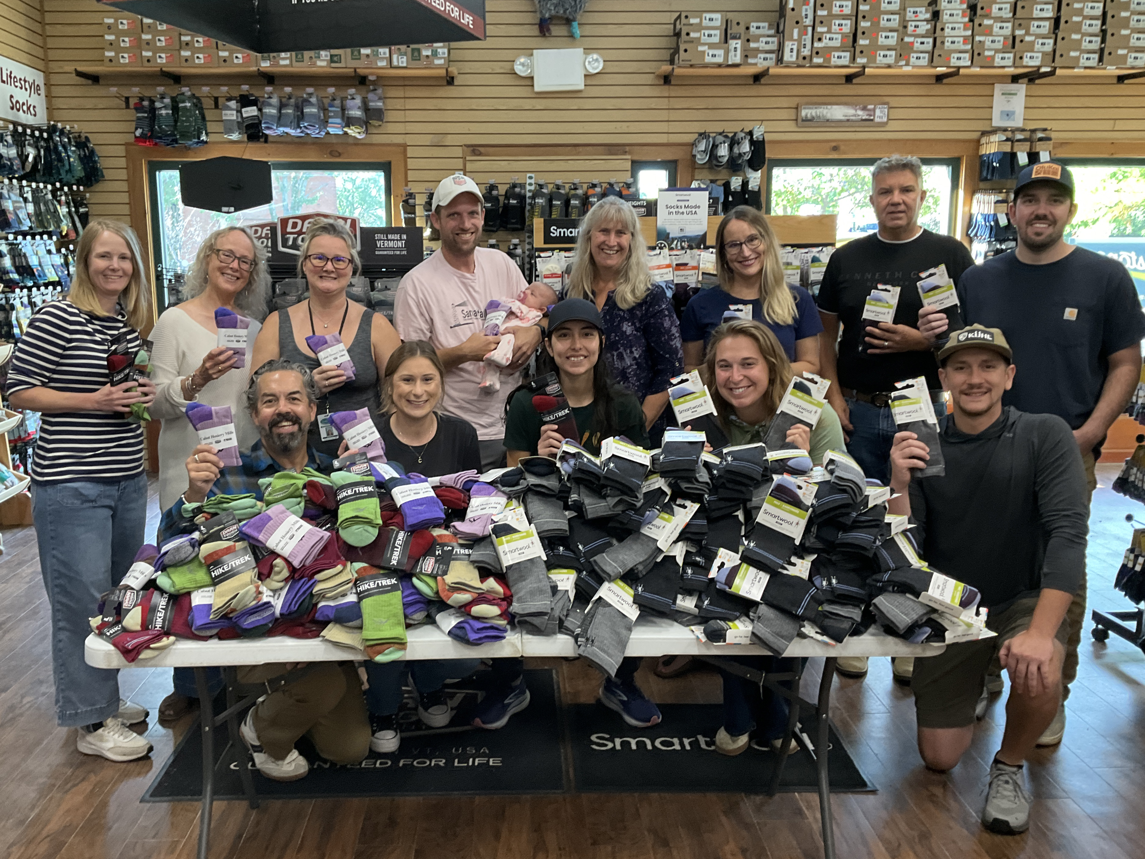 Several people behind a table covered in socks